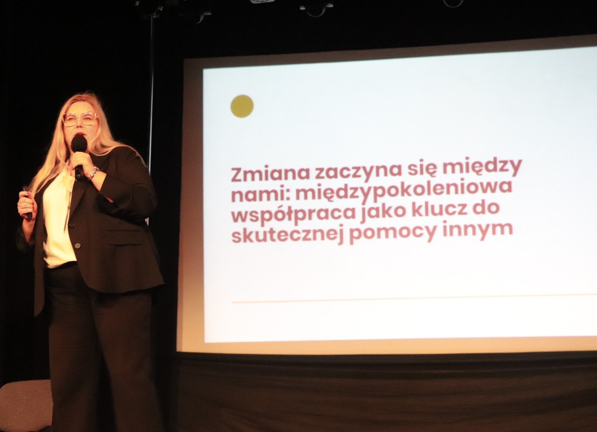 Kobieta w garniturze wygłasza prezentację.