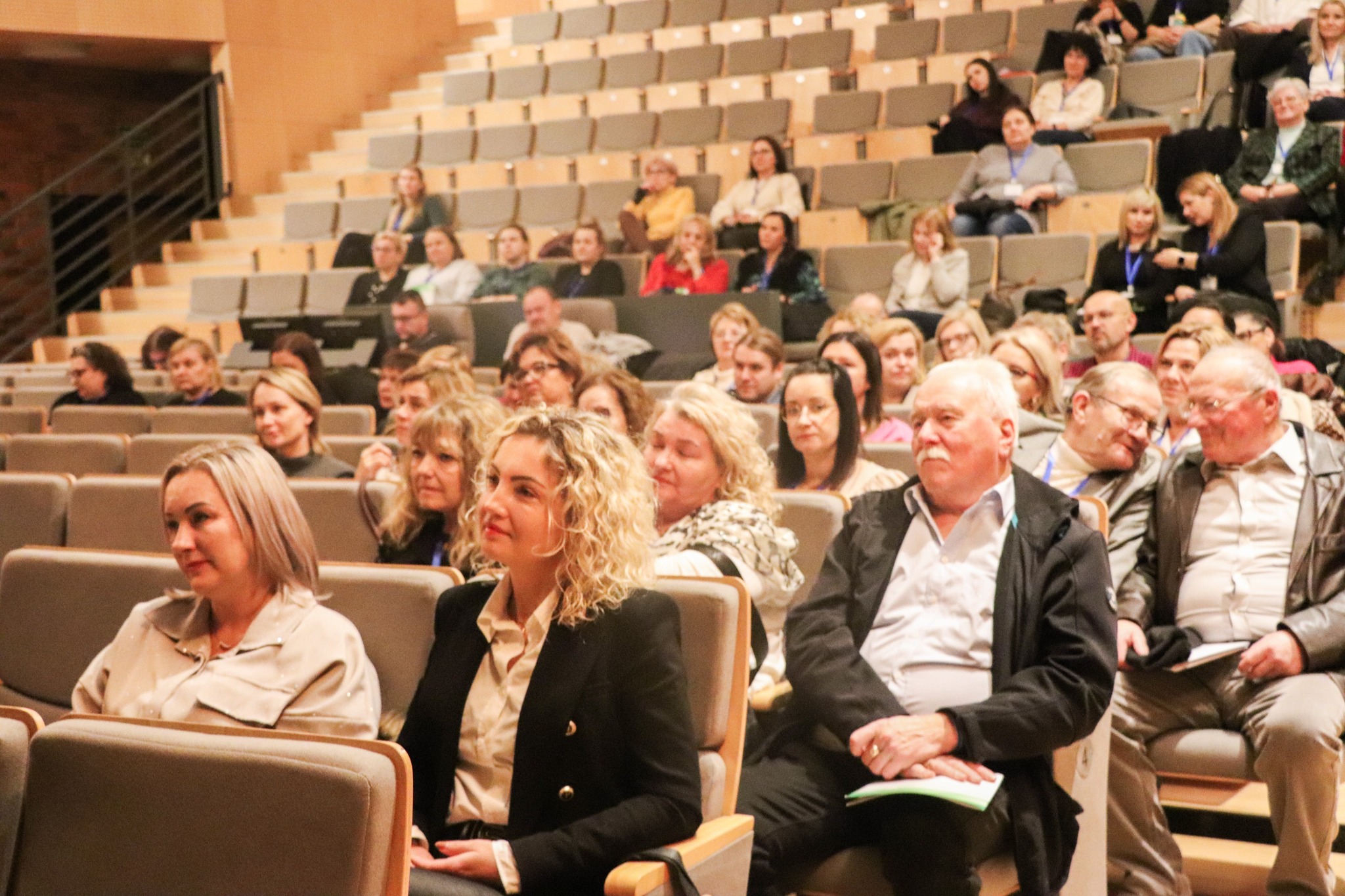 W audytorium zasiada liczna publiczność, skupiona na wydarzeniu na scenie.