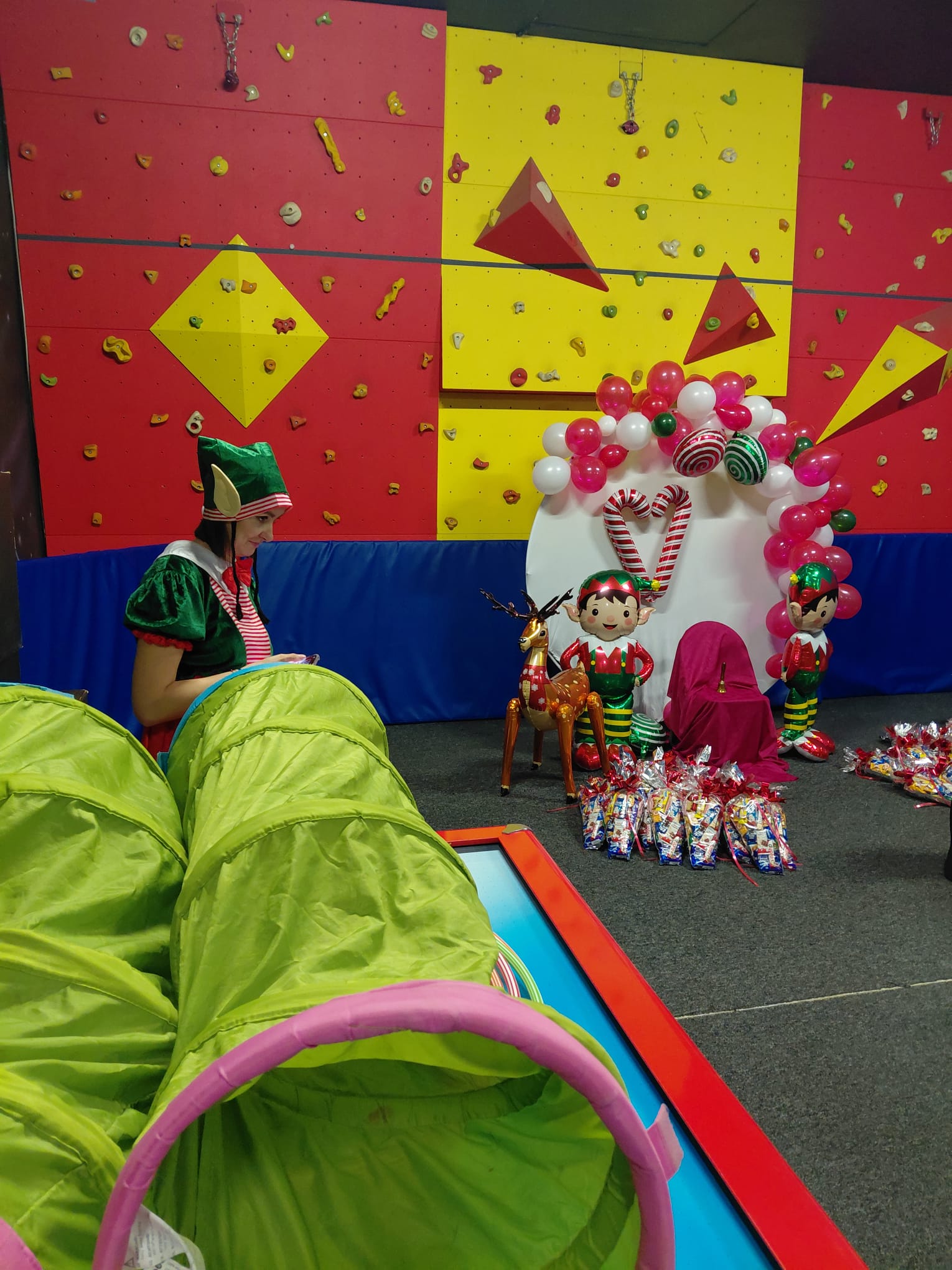 Pomieszczenie z zielonym tunelem, tworzącym przyjazną przestrzeń do zabawy.